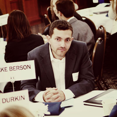 Blake Berson sits at a table before being honored with the Emerging Professional award from the College's Alumni Society Board
