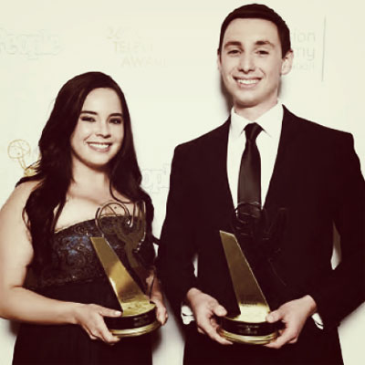 Two students posing with College Television Award Statues