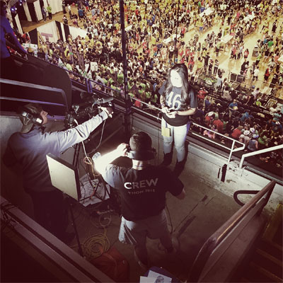 A student reporting crew films above the crowd at THON
