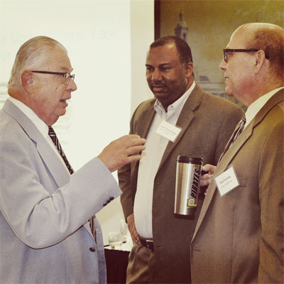 Three conference attendees discussing law enforcement communications