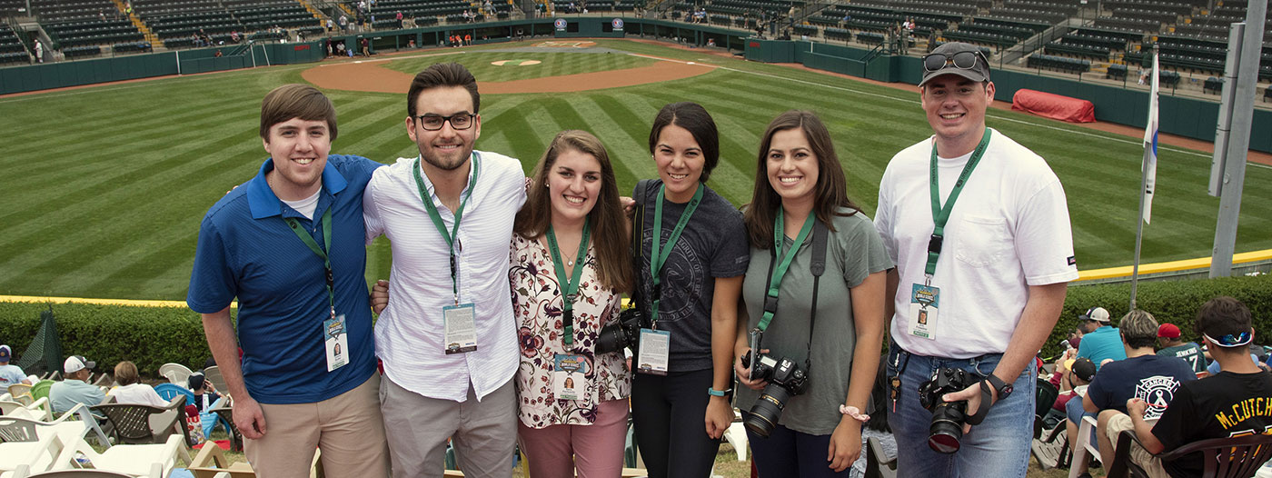 Six journalism students gather on the hill above Howard J. Lamade Stadium while
	covering the Little League World Series