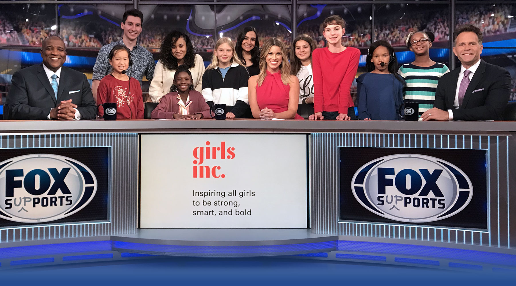 A group of students posing on set at FOX Sports