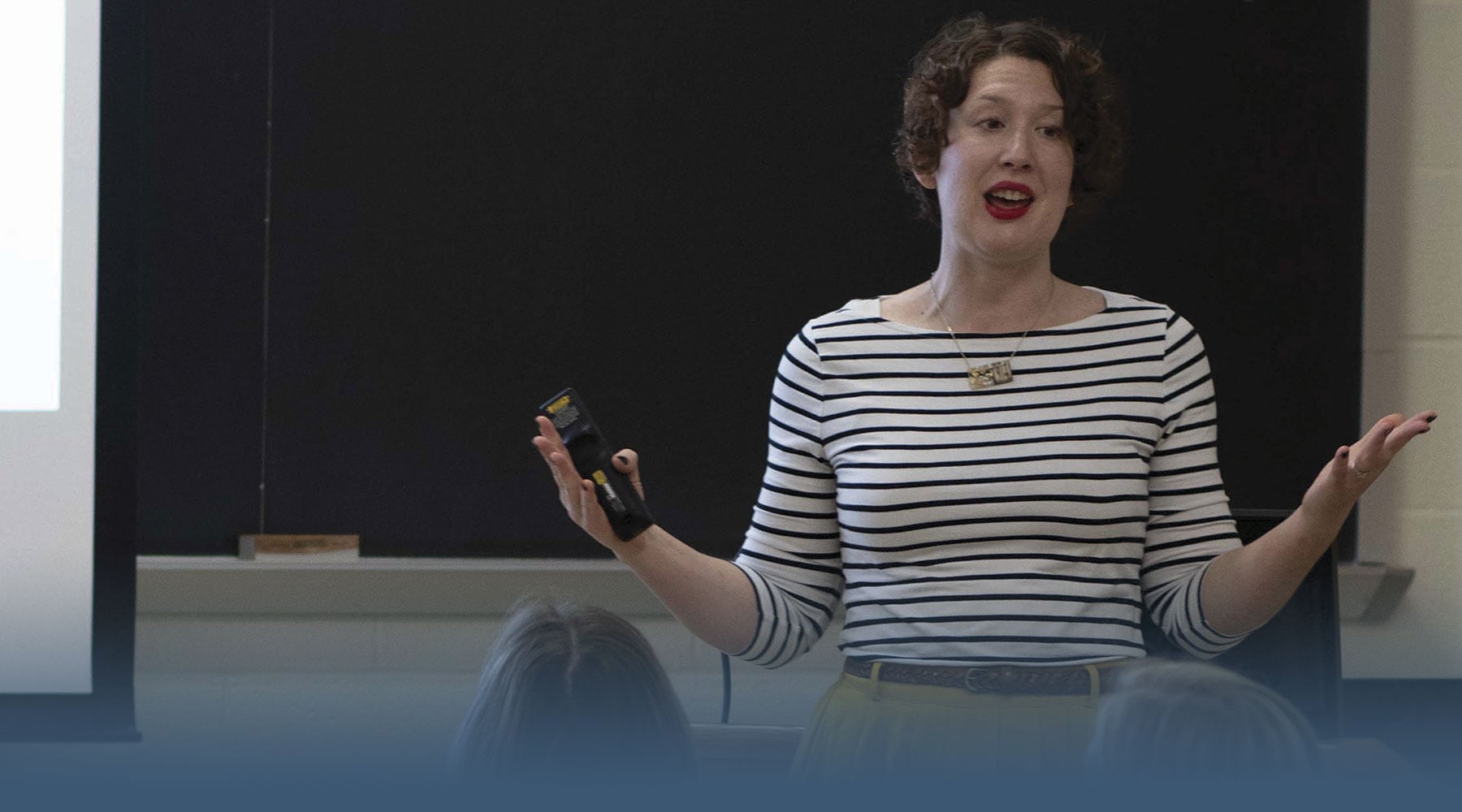 Stephanie Madden, an assistant professor of advertising/public relations stands in front of a classroom teaching research methods.