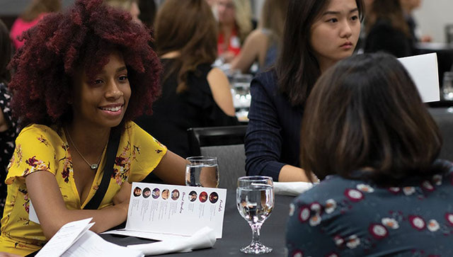 Students at a mentoring event, chat with College alumni