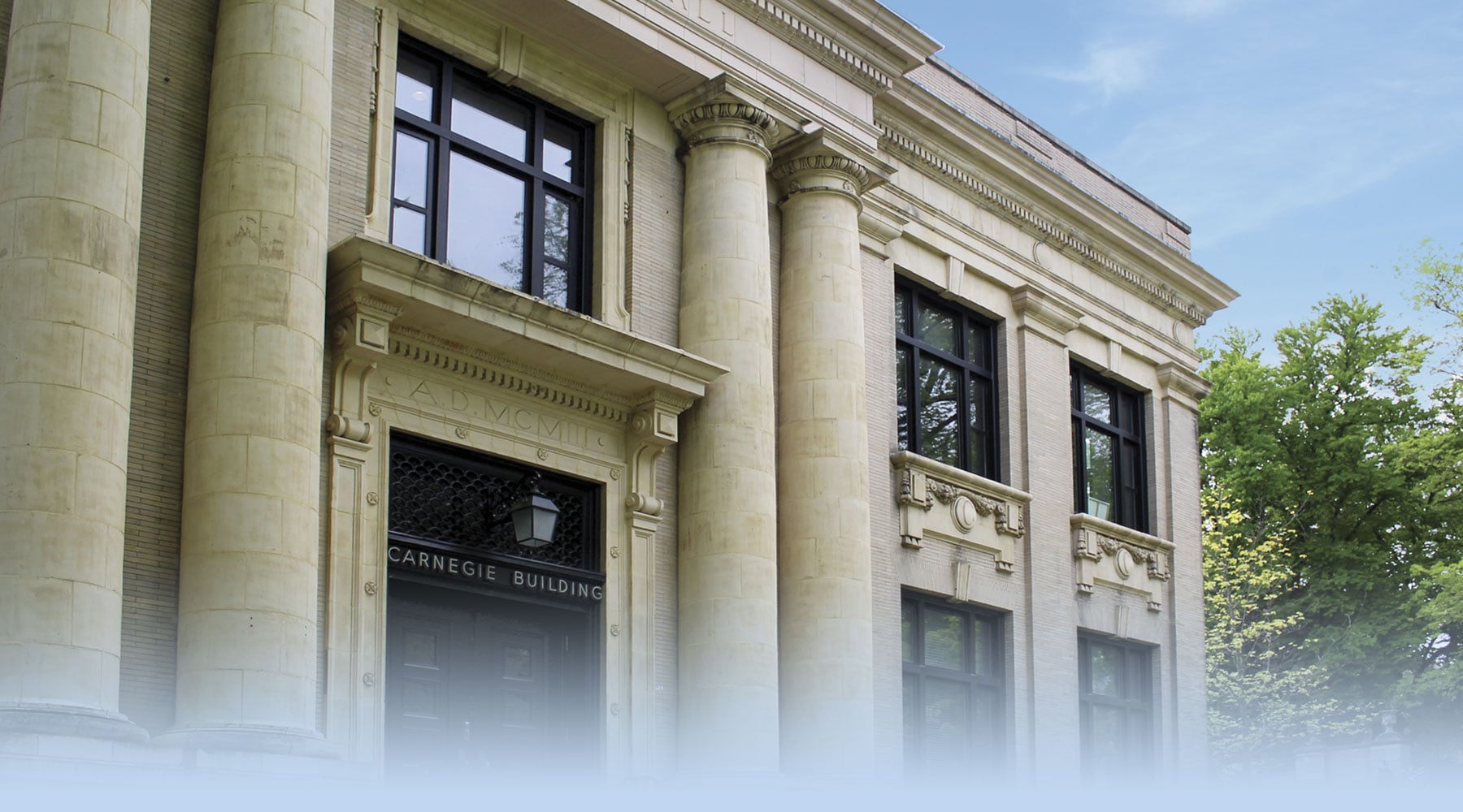 Front entrance of the Carnegie Building on a blue-skied summer day.