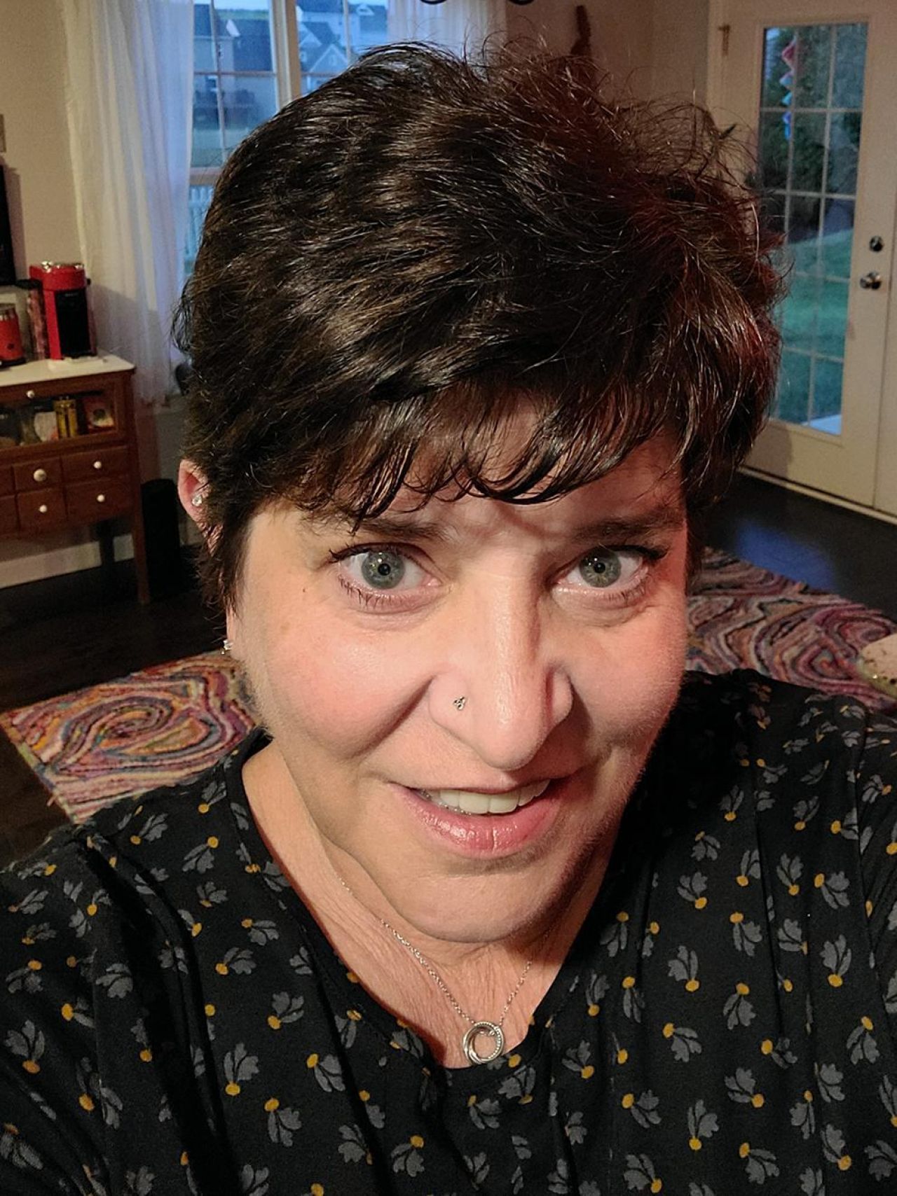 Headshot of woman with short dark hair and a dark top with leaf pattern