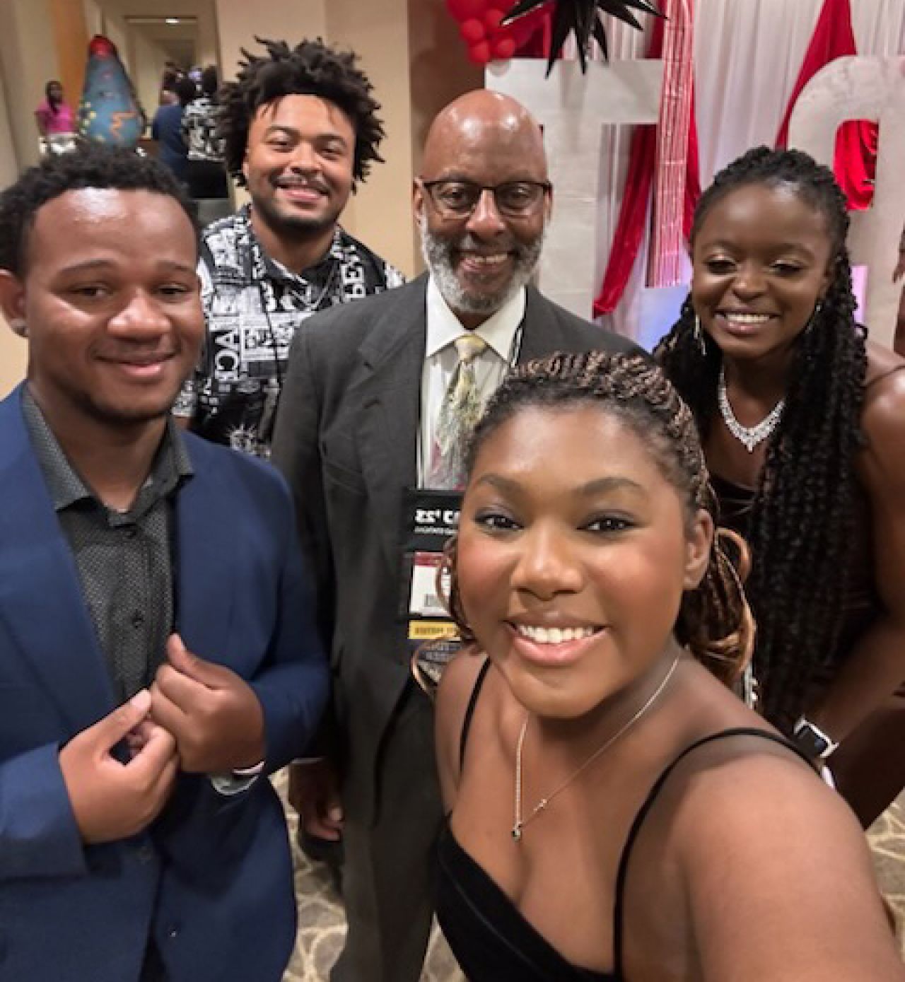 Group of student with a faculty member, smiling straight at camera