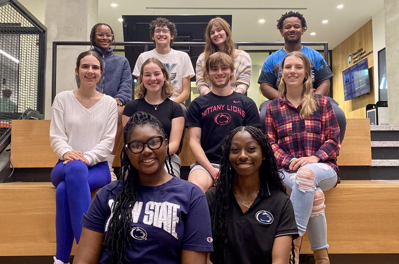 Three rows of students sitting on some steps