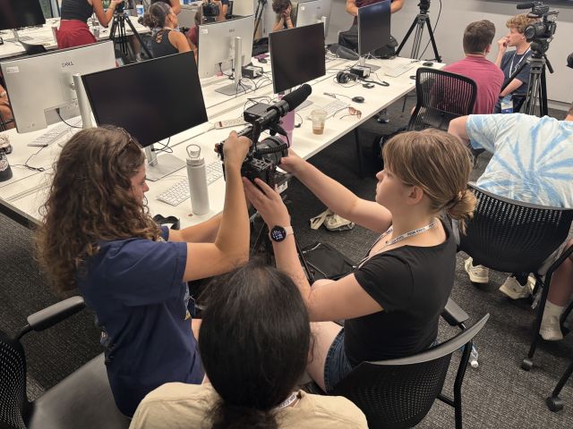 Three students test a camera