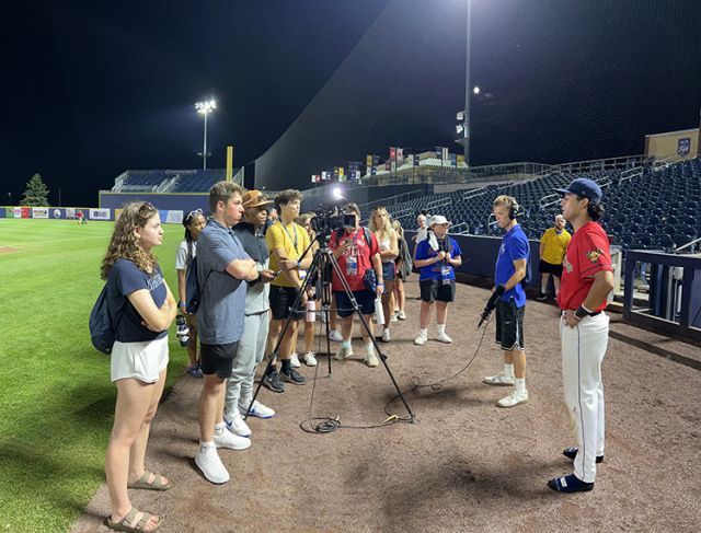 GRoup around baseball player.