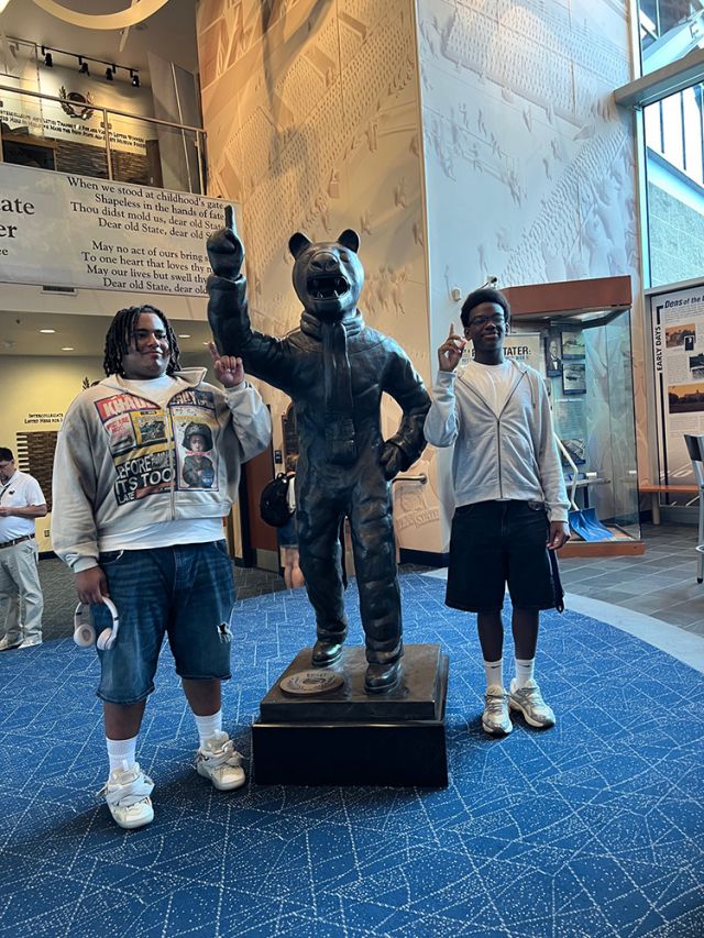 Fingers up with statue.