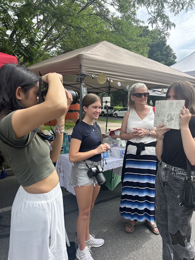 Students taking photos near a person and canopy