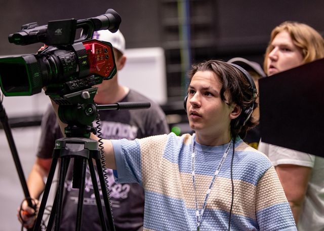 A student checks on focusing a camera.