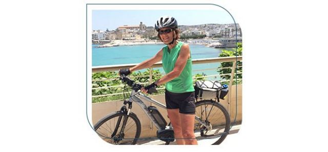 Woman standing next to bike in Puglia, Italy