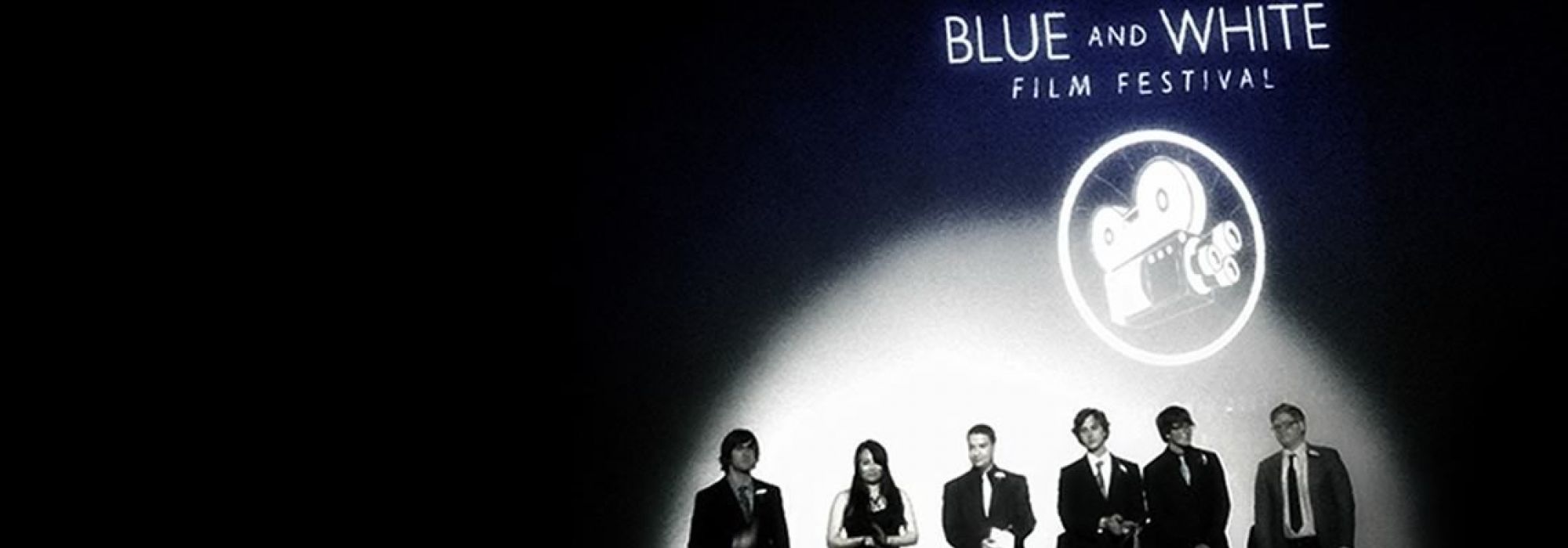 Six students stand on stage during presentations at the Blue and White Film Festival.