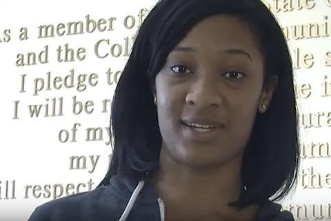 A student poses in front of the College's ethics pledge