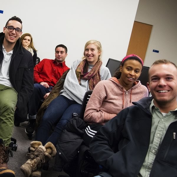 A group of students in class relax and pose for the camera