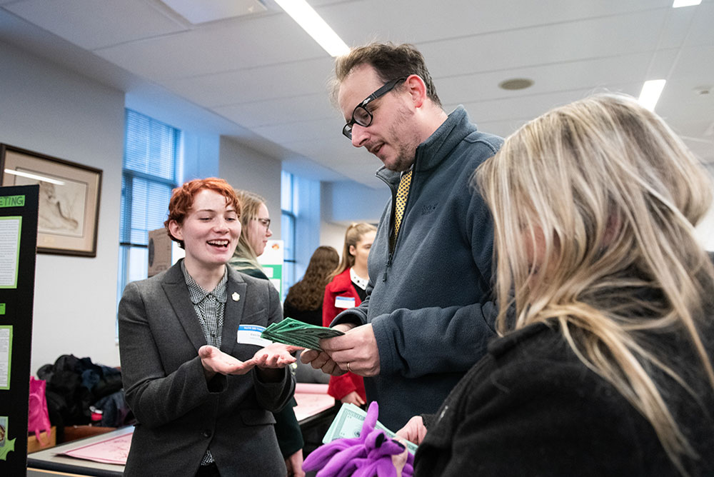 A faculty member and student interacting at a marketing demo.