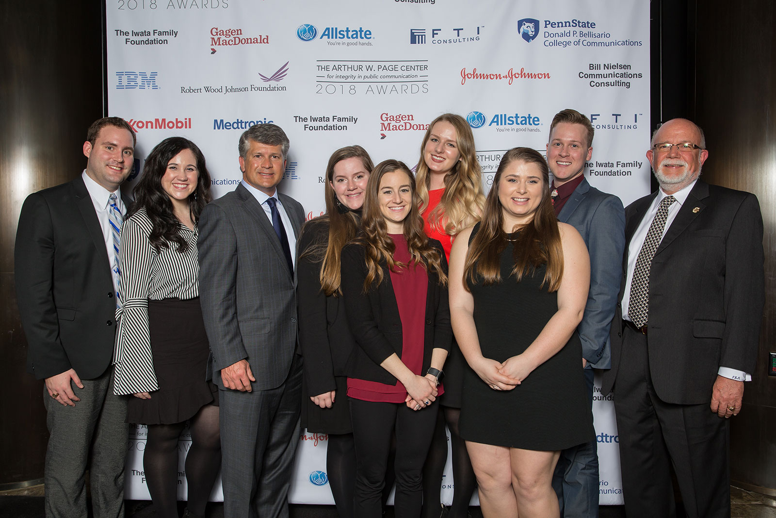 The College of Charleston table smiling in front of the Center's wall of sponsors.