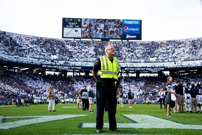 A police officer standing in the end zone of Beaver Stadium as the crowd leaves post-game.
