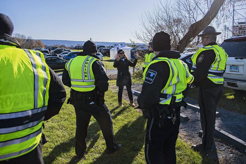 A tailgater asking several police officers for assistiance in locating her vehicle after a game.