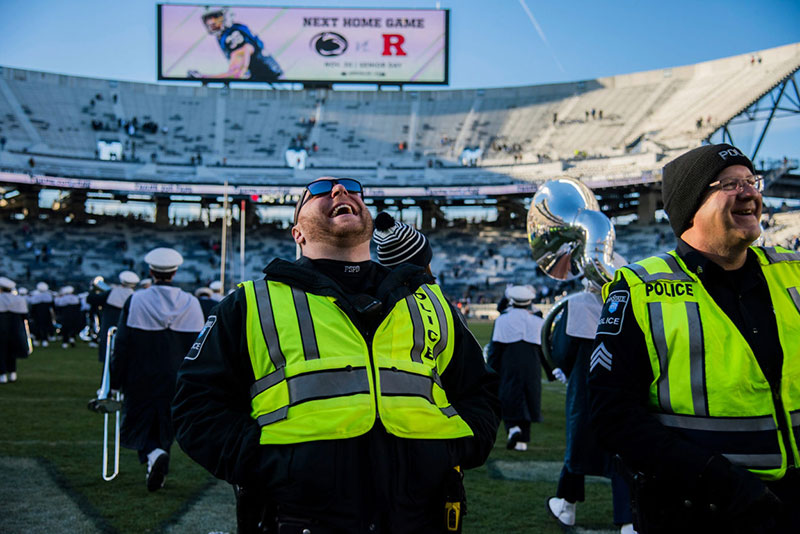 Two police officers share a laugh in the end zone after a game at Beaver Stadium.