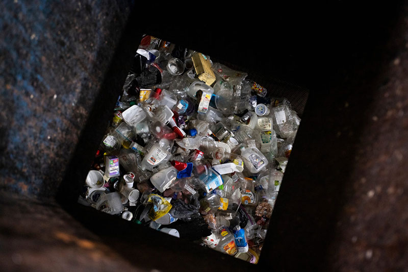 A pile of plastic containers is seen below a sorting chute.