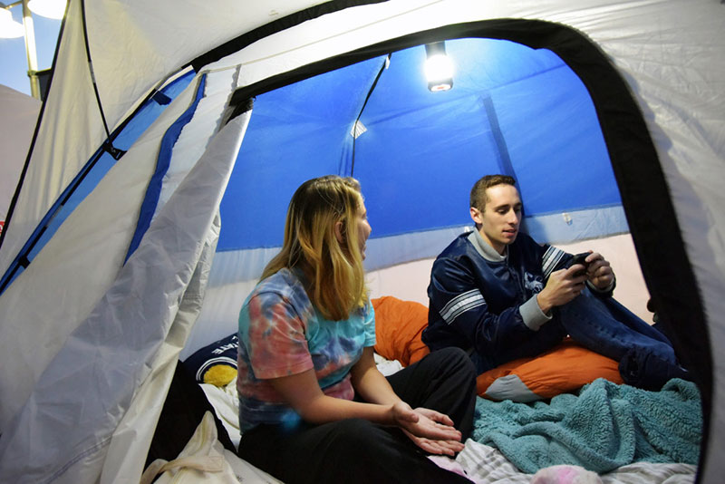 A couple sitting inside a tent in advance of a Penn State football game.