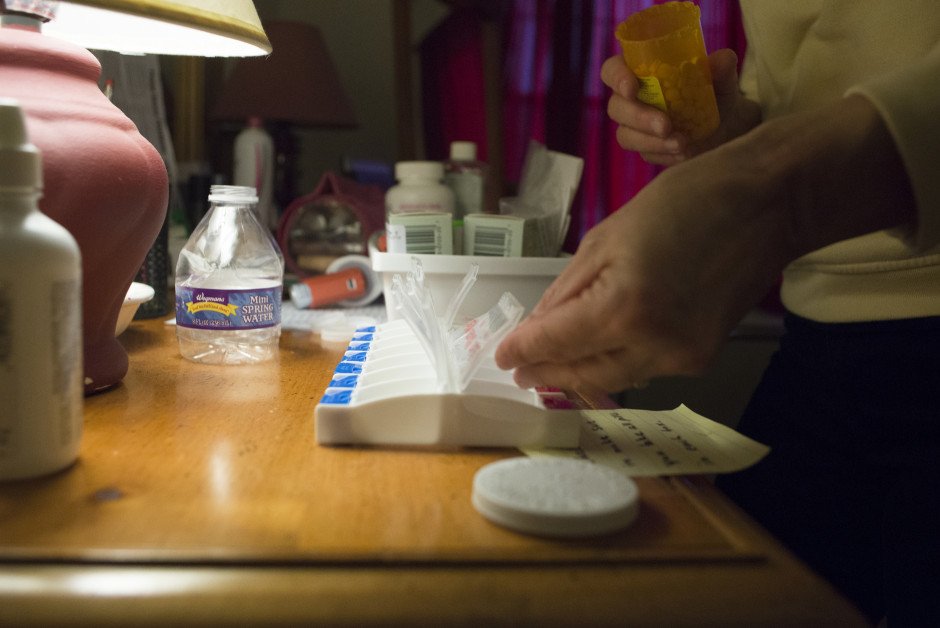 Lisa filling a weekly pill dispenser with medications.