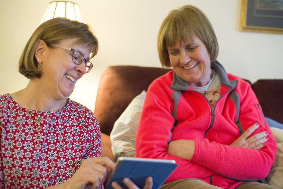 Lisa and Cindy look at photographs on an iPad