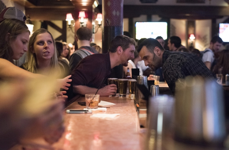 Zack leans across several beers on the bar at Bill Pickles' talking to the bartender