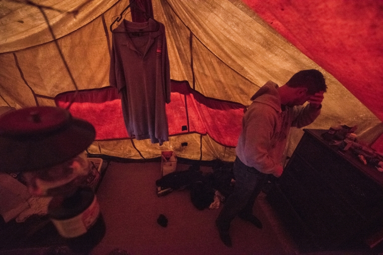 Inside his tent, Zack rubs his eyes as he gets up for class.