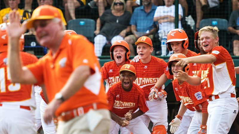 Southwest Manager Bud Maddux high fives infielder Mark Requena as he rounds third after hitting a two run homer in the Little League World Series.